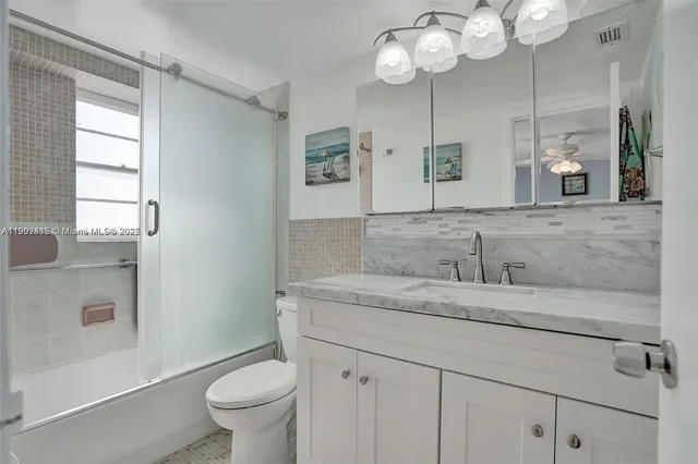 a bathroom with a granite countertop sink mirror and vanity