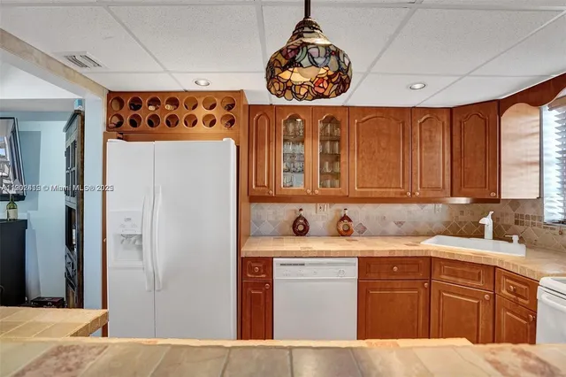 a kitchen with stainless steel appliances a sink a refrigerator and cabinets