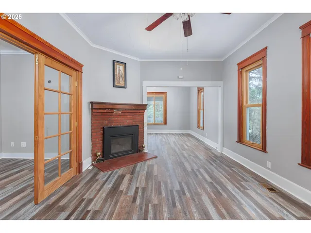 a living room with a fireplace and wooden floor