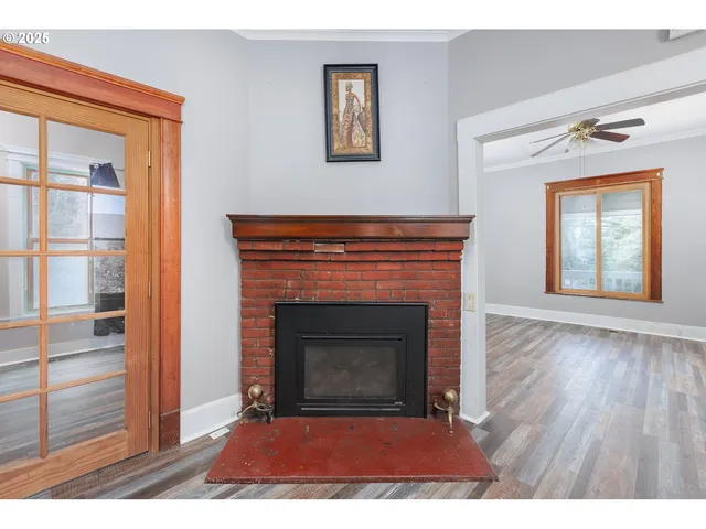 a view of empty room with wooden floor and fireplace