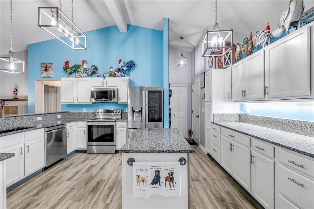 7 Ranbay Place Palm Coast, FL 32164 - Photo 12 of 76 a kitchen with granite countertop stainless steel appliances a stove top oven a sink and cabinets