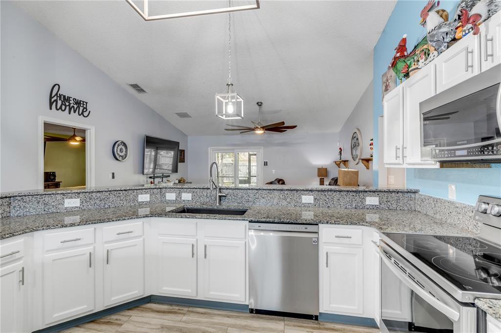 7 Ranbay Place Palm Coast, FL 32164 - Photo 19 of 76 a kitchen with granite countertop a sink stainless steel appliances and cabinets