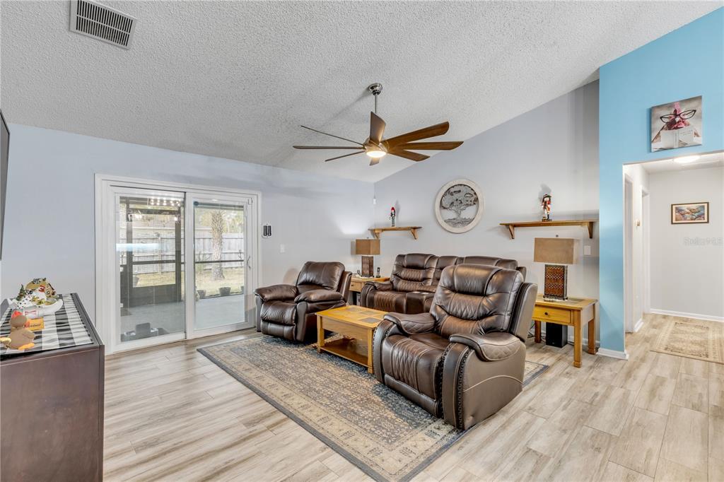 7 Ranbay Place Palm Coast, FL 32164 - Photo 24 of 76 a living room with furniture a clock on wall and a window