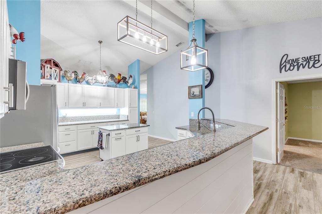 7 Ranbay Place Palm Coast, FL 32164 - Photo 27 of 76 a kitchen with a sink dishwasher and white cabinets with wooden floor