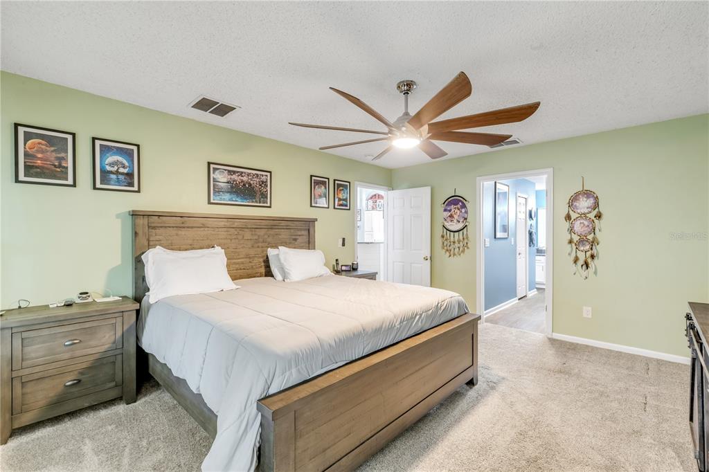 7 Ranbay Place Palm Coast, FL 32164 - Photo 31 of 76 a spacious bedroom with a large bed and a chandelier