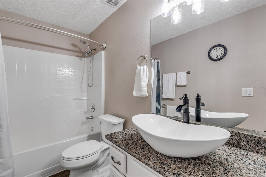 7 Ranbay Place Palm Coast, FL 32164 - Photo 38 of 76 a bathroom with a granite countertop sink toilet a mirror and shower