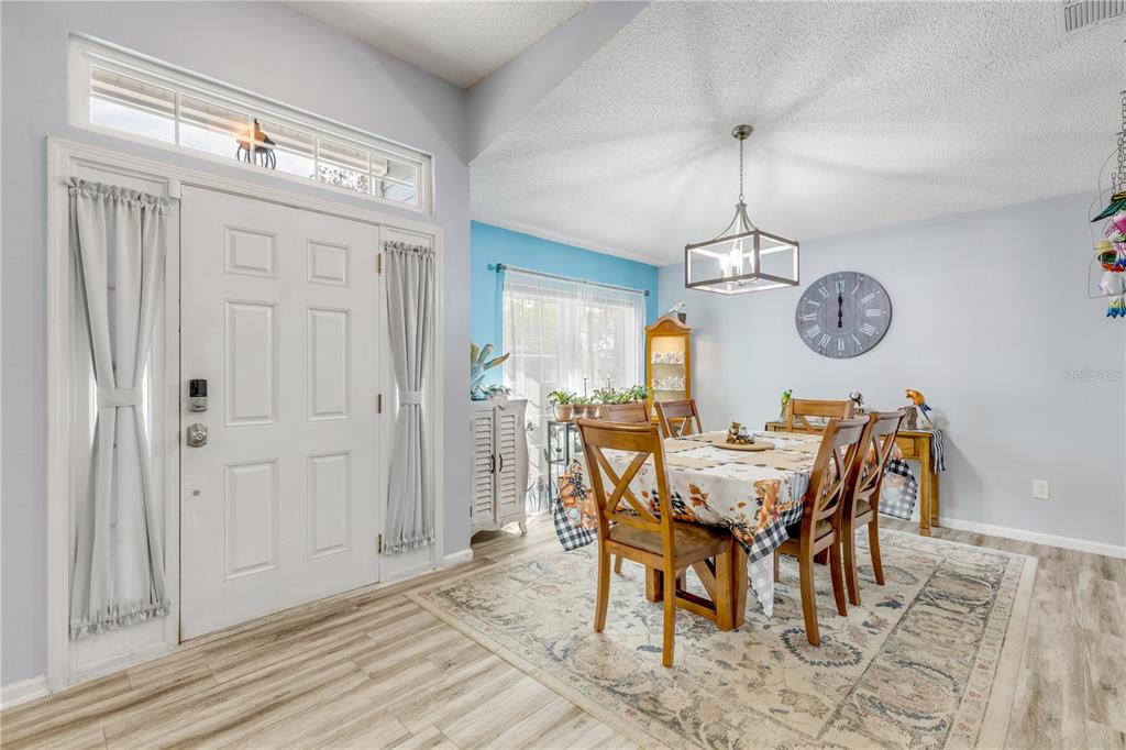 7 Ranbay Place Palm Coast, FL 32164 - Photo 5 of 76 a view of a dining room and kitchen with a table chairs and wooden floor
