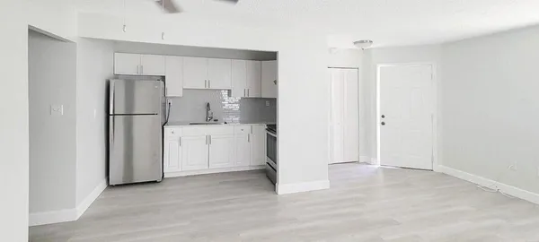 a kitchen with a refrigerator a sink and cabinets