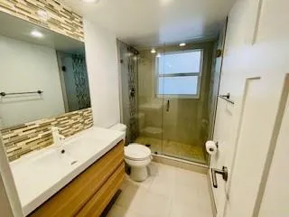 a bathroom with a sink a toilet and shower