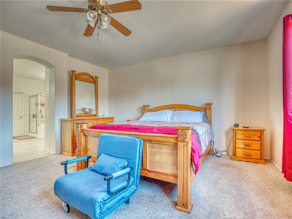 39233 Chantilly Lane Palmdale, CA 93551 - Photo 16 of 31 a bedroom with a bed and a chandelier