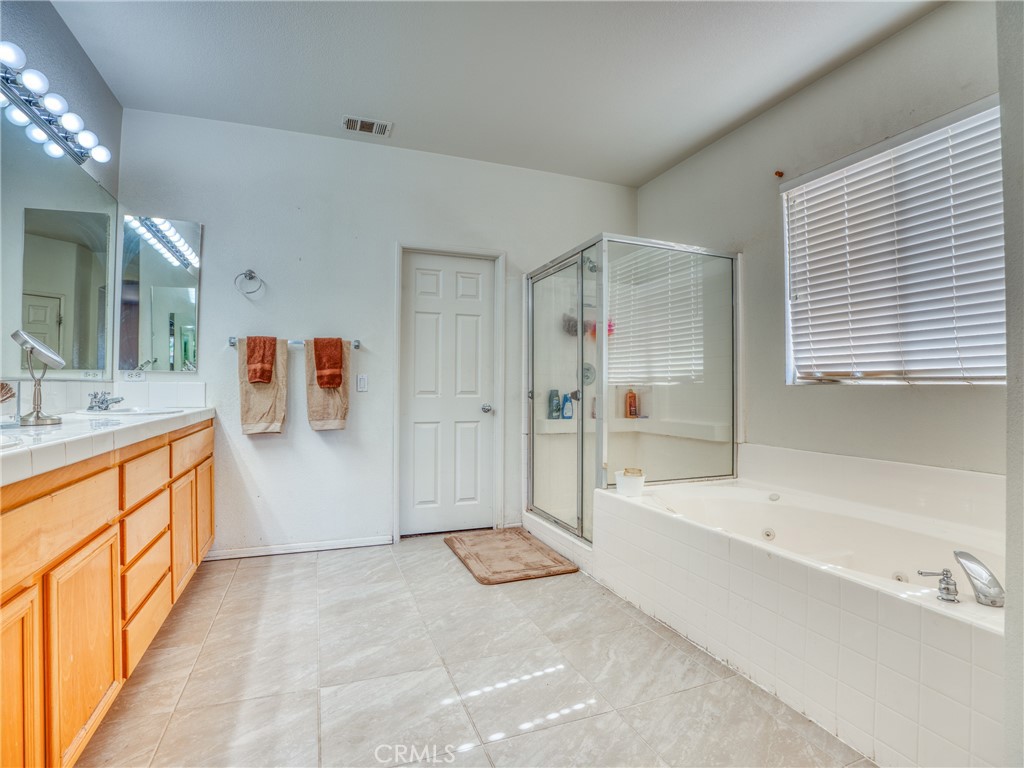 39233 Chantilly Lane Palmdale, CA 93551 - Photo 17 of 31 a spacious bathroom with a tub sink shower and mirror