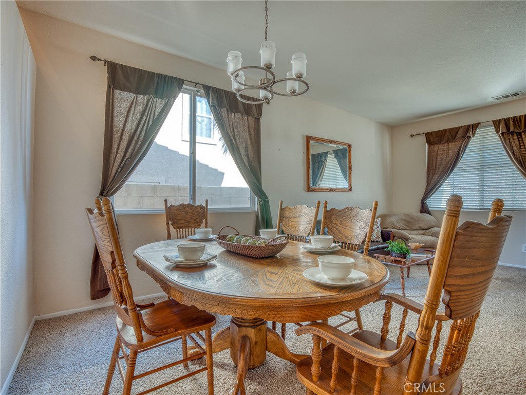 39233 Chantilly Lane Palmdale, CA 93551 - Photo 4 of 31 a view of a dining room with furniture window and wooden floor