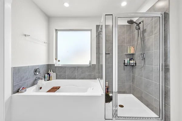 a bathroom with a tub a sink and a shower