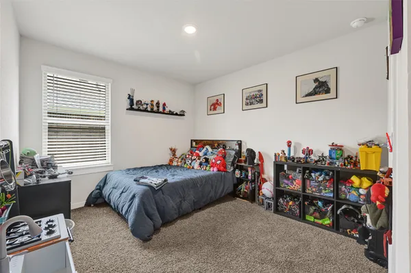 a bedroom with a bed a couch and a window