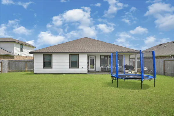 a backyard of a house with table and sofas