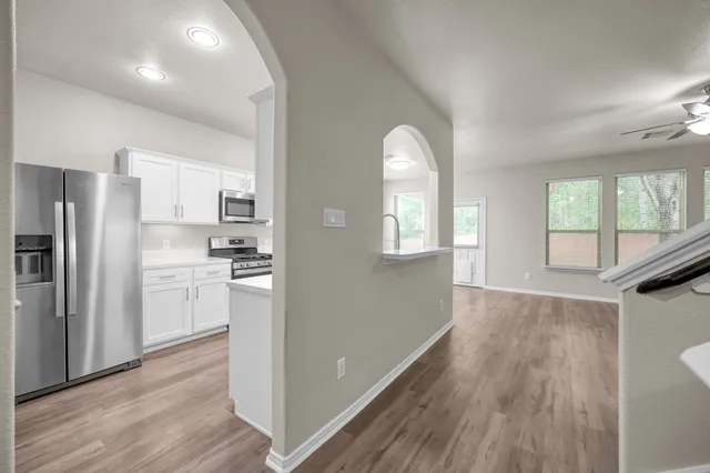 a kitchen with a refrigerator and wooden floor