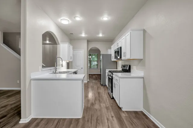 a kitchen with stainless steel appliances granite countertop a sink and cabinets