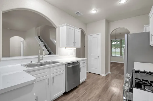 a kitchen with a sink cabinets and wooden floor