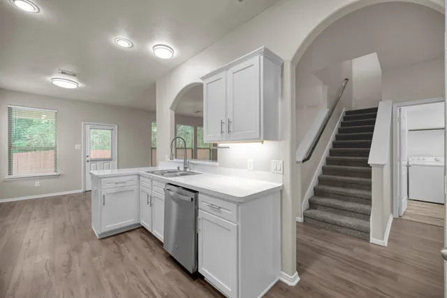 an open kitchen with a sink and dish washer