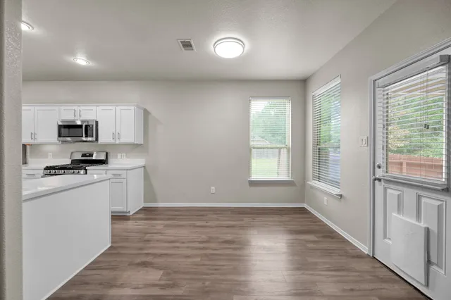 a kitchen with stainless steel appliances granite countertop a stove a sink and a refrigerator