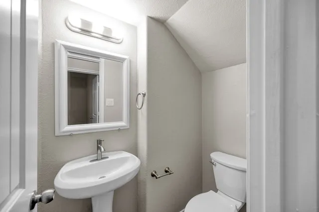 a bathroom with a sink toilet and mirror