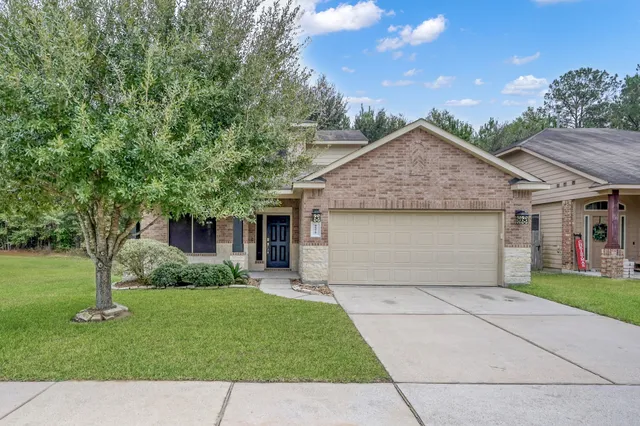 a front view of a house with a garden and trees