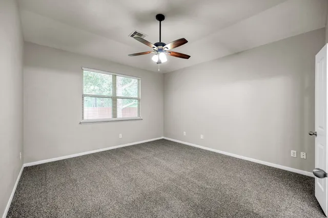 an empty room with a window and a fan