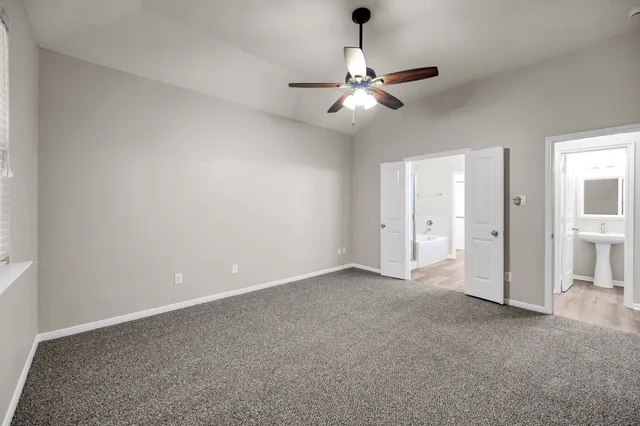 an empty room with closet and a chandelier fan