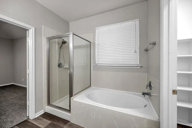 a white bath tub sitting next to a shower