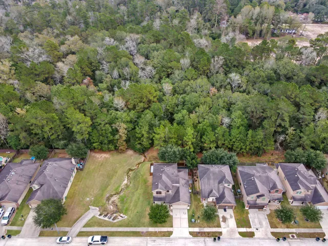 an aerial view of residential houses with outdoor space and parking