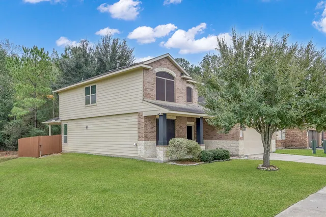 a front view of a house with a garden and trees