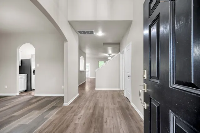 a view of a hallway with wooden floor and stairs