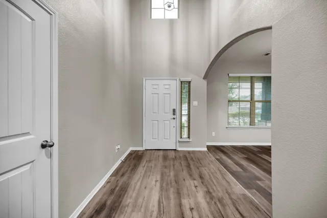a view of a room with wooden floor and windows