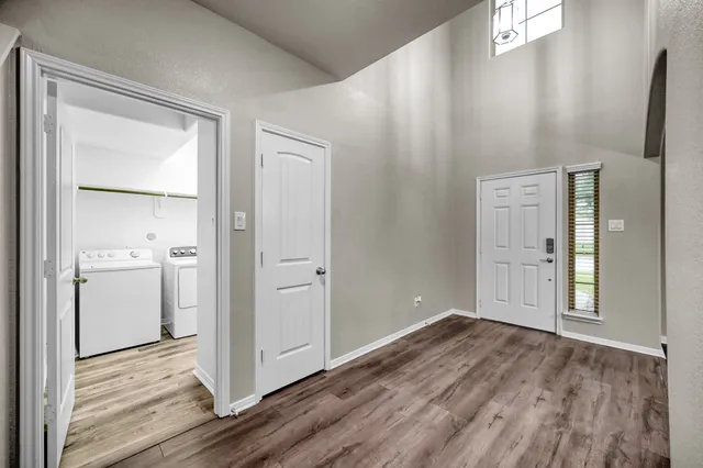 a view of empty room with wooden floor and window