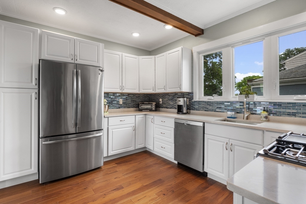 21 Little Nahant Road Nahant, MA 01908 - Photo 13 of 35 a kitchen with wooden floors white cabinets and stainless steel appliances
