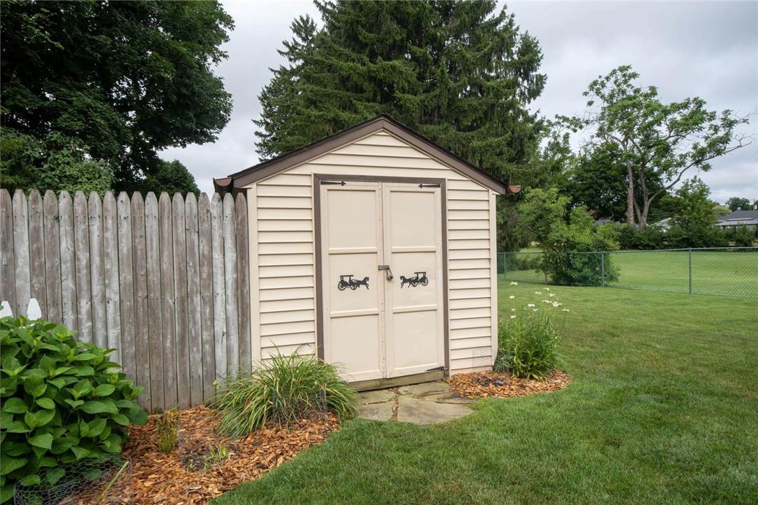 706 Stones Crossing Road Easton, PA 18045 - Photo 33 of 40 A quaint storage shed offers functional outdoor utility, set beside a wooden fence within a green yard.