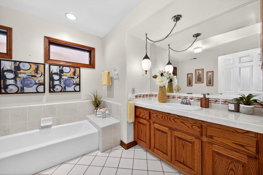 7730 McCourtney Road Lincoln, CA 95648 - Photo 44 of 99 a spacious bathroom with a granite countertop sink mirror and a bathtub