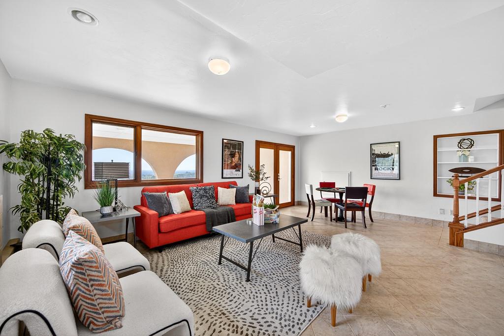7730 McCourtney Road Lincoln, CA 95648 - Photo 51 of 99 a living room with furniture potted plant a fireplace and a large window