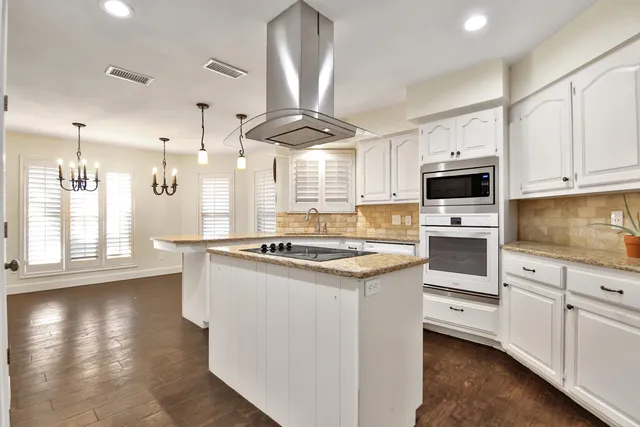 a kitchen with granite countertop a stove a sink and a refrigerator
