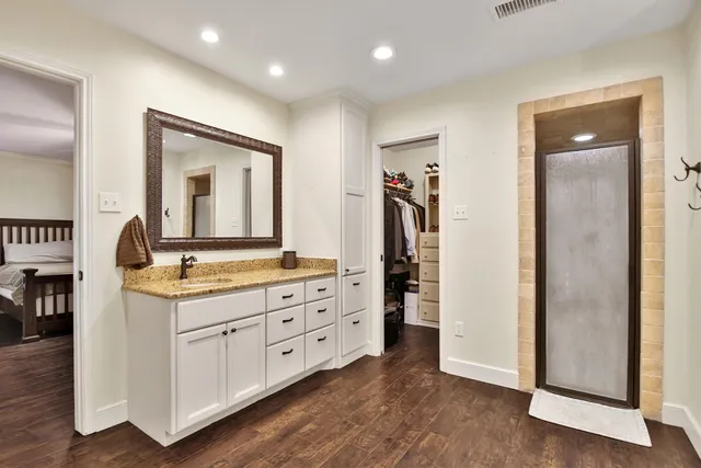 a bathroom with a granite countertop sink and a mirror