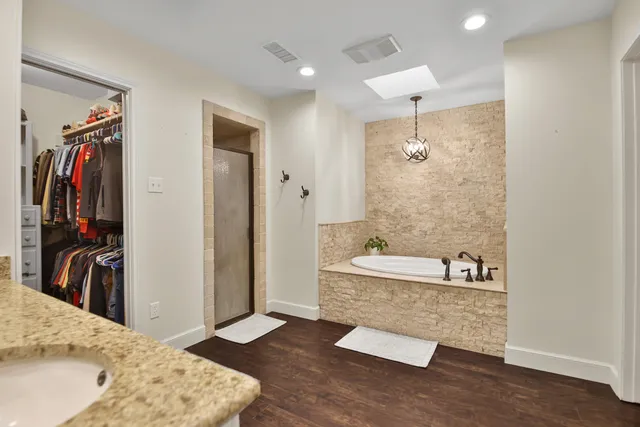 a bathroom with a tub sink and mirror