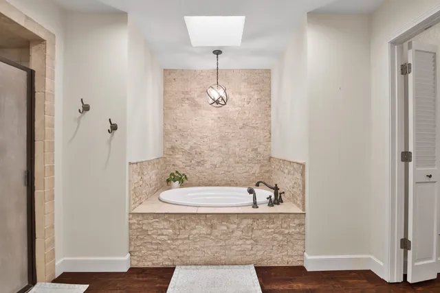 a bathroom with a granite countertop sink a mirror and shower