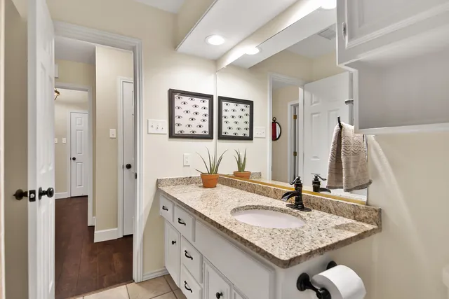 a bathroom with a granite countertop sink and a mirror