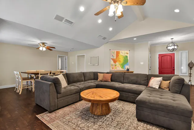 a living room with furniture a chandelier and a rug