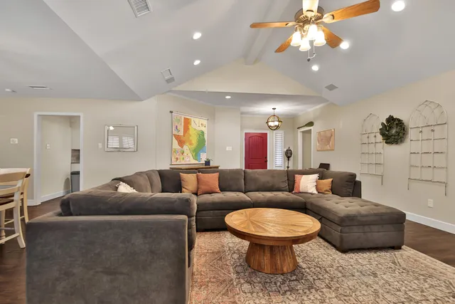 a living room with furniture a ceiling fan and a rug