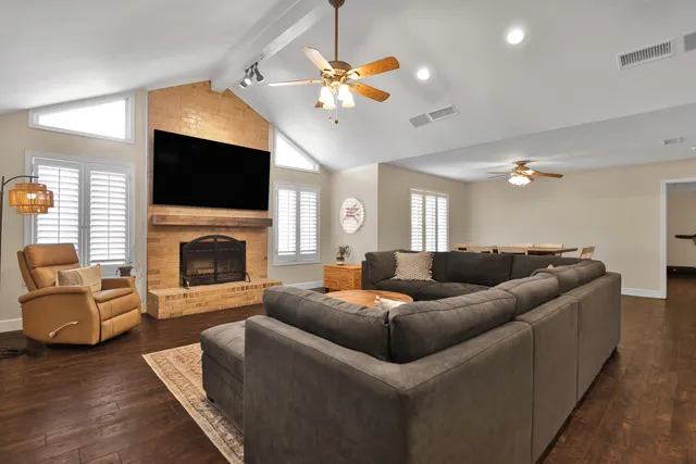 a living room with furniture a flat screen tv and a fireplace