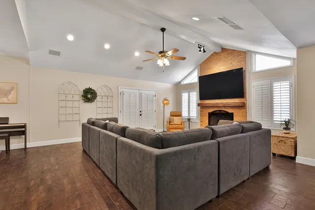 a living room with furniture a fireplace and a flat screen tv