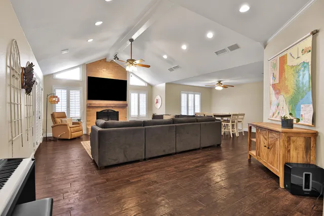 a living room with furniture a flat screen tv and a fireplace