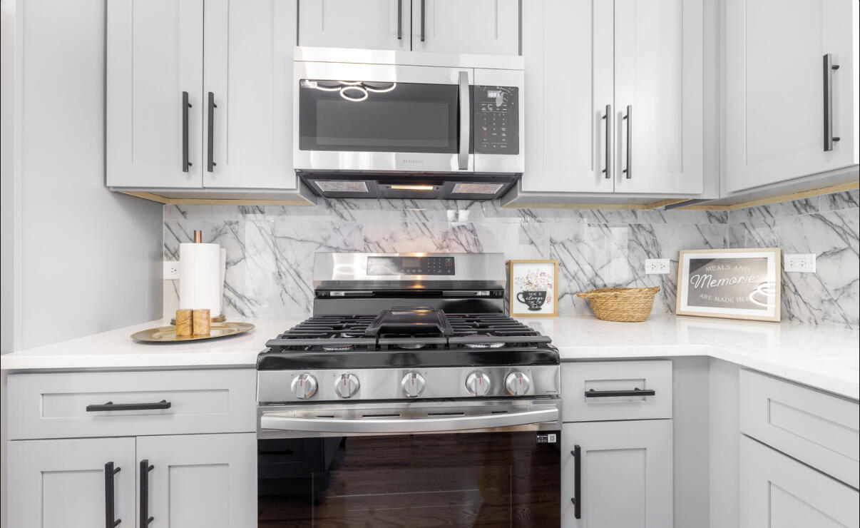 419 Cleveland Street Gary, IN 46404 - Photo 12 of 42 a kitchen with stainless steel appliances granite countertop white cabinets and a stove
