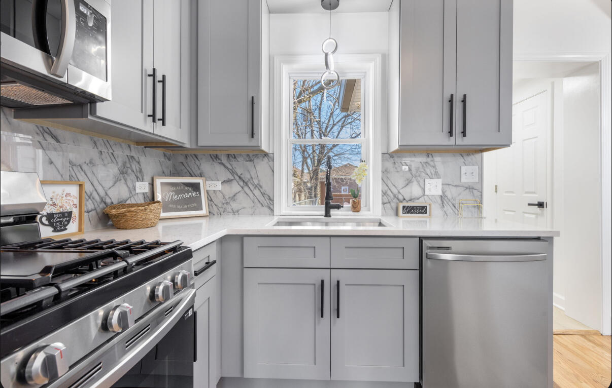 419 Cleveland Street Gary, IN 46404 - Photo 13 of 42 a kitchen with stainless steel appliances white cabinets and a stove